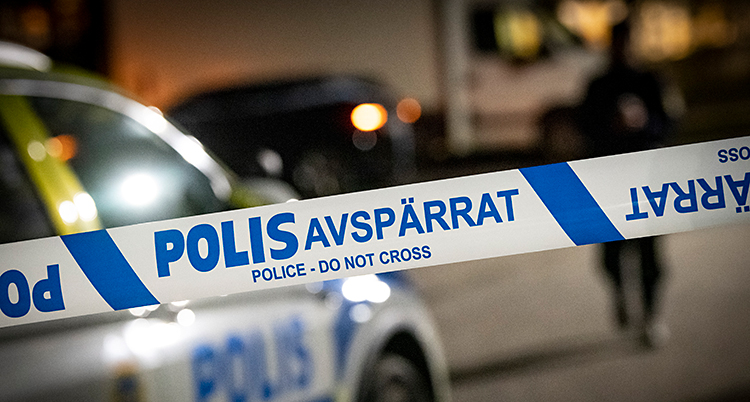 Bilden är tagen utomhus. Poliserna har satt upp ett band för att spärra av.