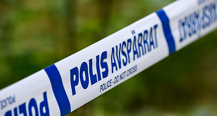 Poliser har satt upp ett band och spärrat av. I bakgrunden syns skog.