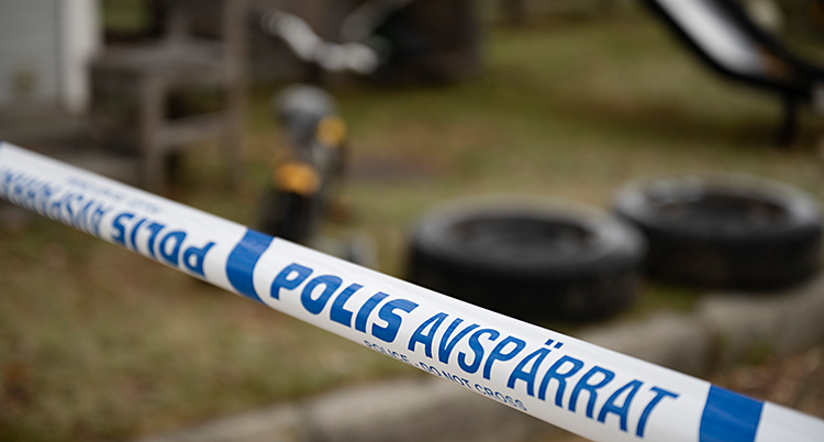Poliserna har satt upp ett blått och vitt band utanför ett hus.