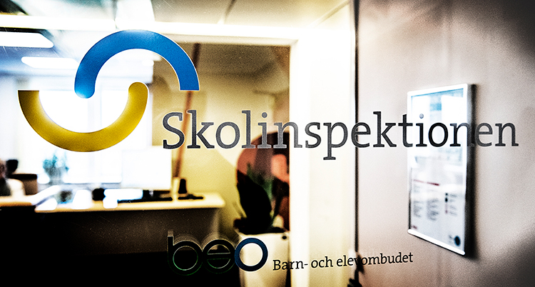 Skolinspektionens logga på en glasvägg.