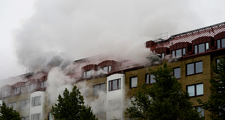 Rök väller ut från huset.