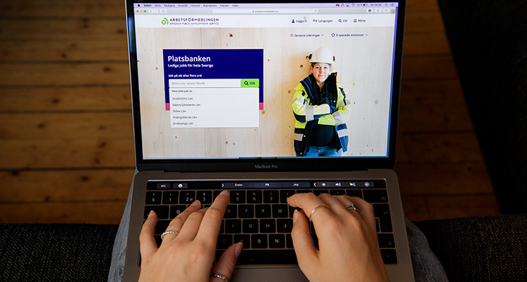 Två händer skrivet på ett tangentbord. På skärmen syns en sajt för jobb.
