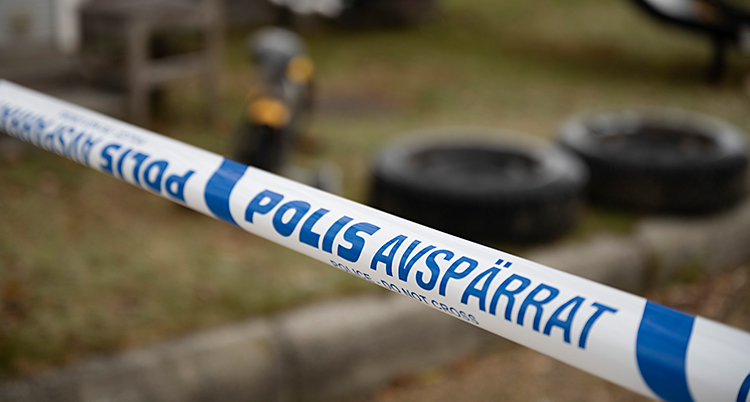 Poliser har spärrat av med band utanför ett hus.
