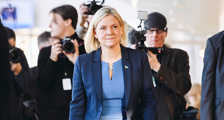 Hon går i en korridor. Många fotografer tar bilder på henne.