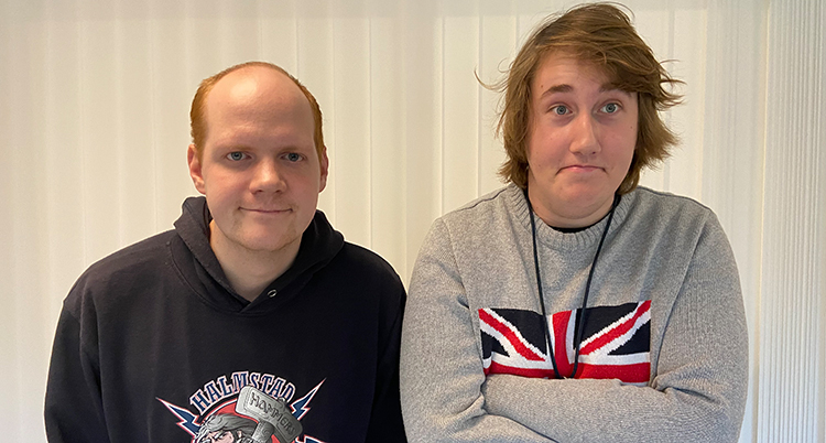 De står intill varandra mot en vit bakgrund, de tittar in i kameran