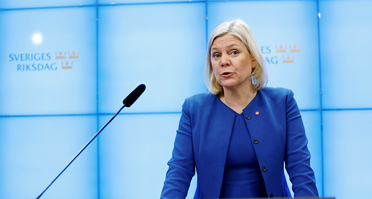 Hon har blå kläder och talar i en mikrofon