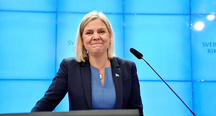 Hon ler och har en mikrofon framför sig.