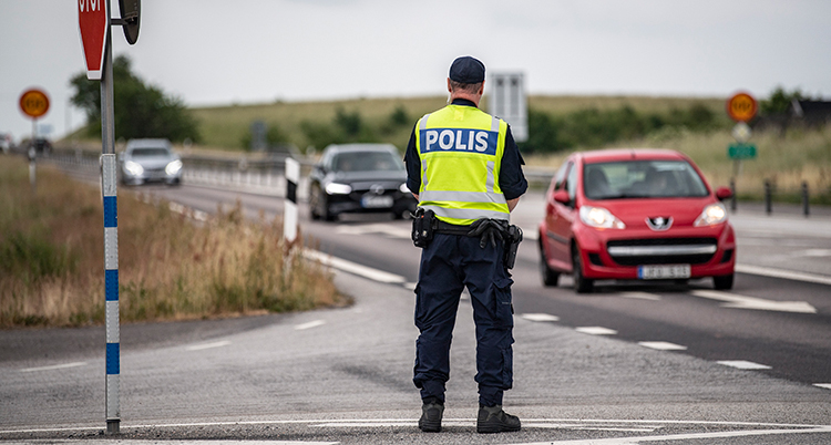 En polis bredvid en väg.