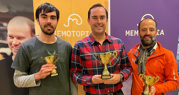 De står bredvid varandra. De håller i varsin pokal.