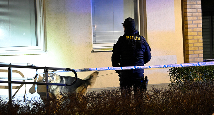En polis står utanför en bostad.