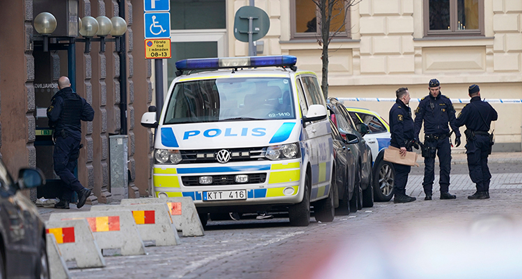 Polisbuss och poliser på gatan utanför skolan.