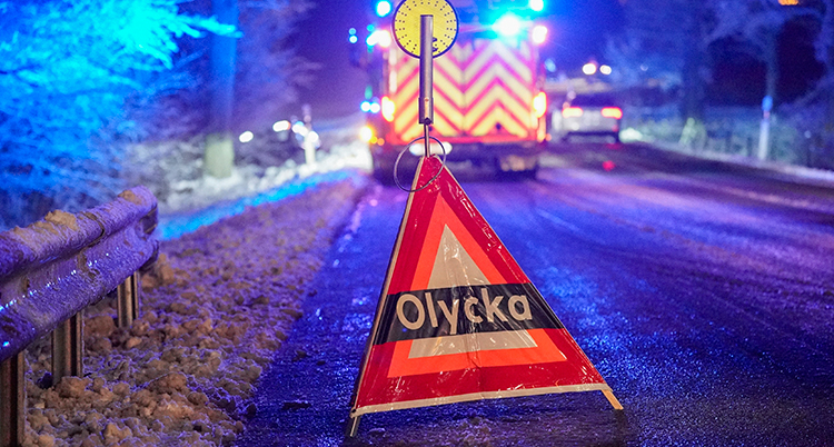En skylt där det står olycka. En brandbil står bakom den.