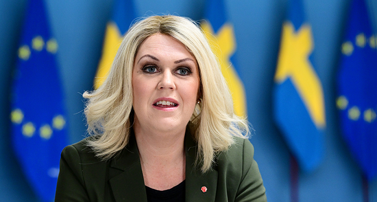 Hon tittar in i kameran.