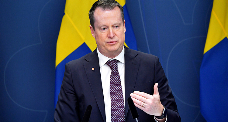 Han lyfter handen när han pratar med medierna.