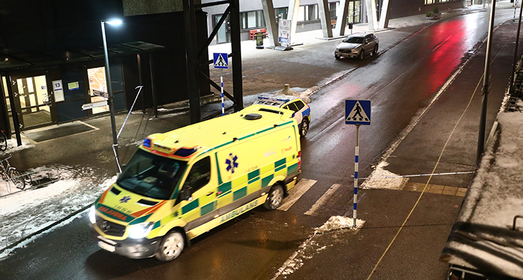 En ambulans på en mörk gata.