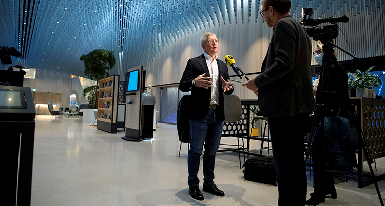 Ericsson står vid två män som håller fram en mikrofon.