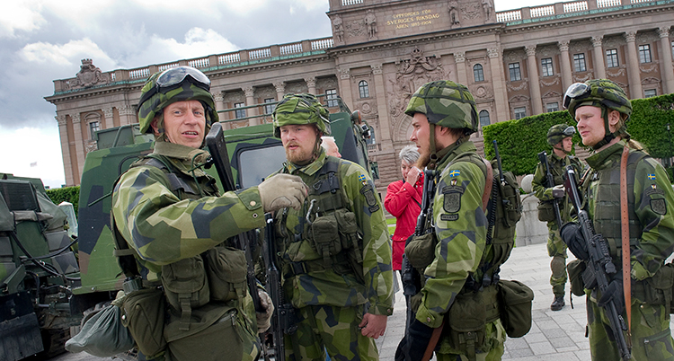Fyra soldater i uniform står framför slottet.