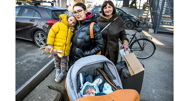 De står intill varandra. I förgrunden syns en baby i en barnvagn