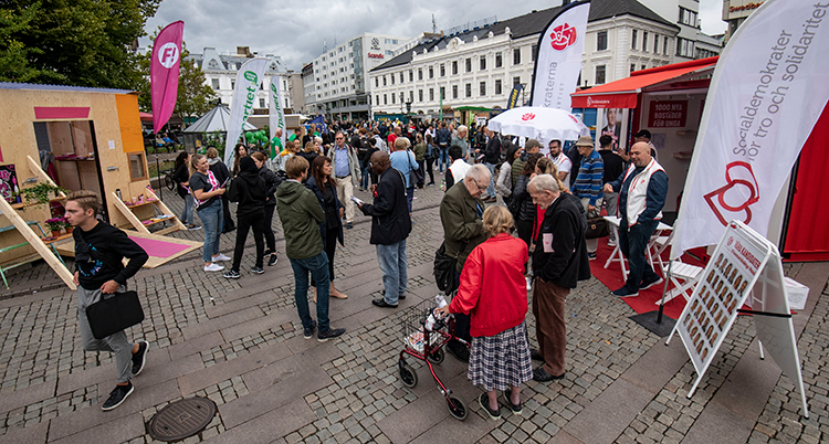 Människor på ett torg. Flaggor från flera partier.