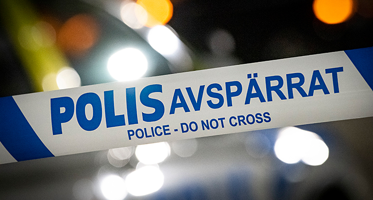 Närbild på ett band som poliserna har satt upp. Det står Polis Avspärrat på bandet.