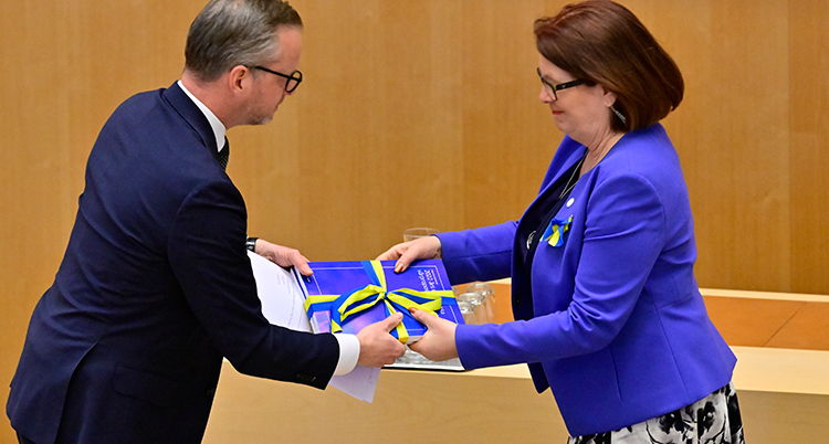 Damberg räcker över en lunta med papper till talmannen.