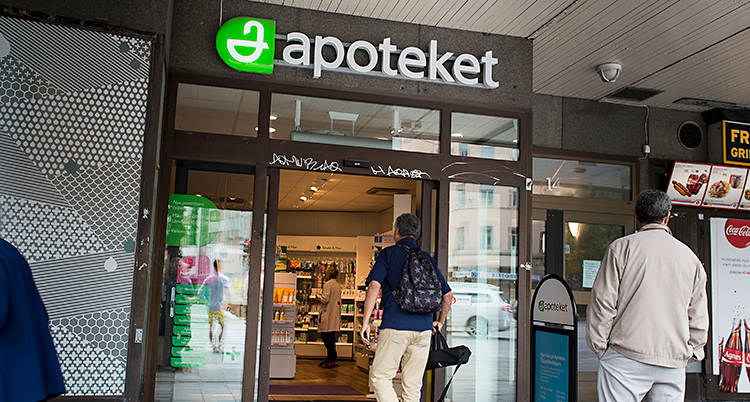 Vi ser utsidan av en butik. En man är på väg in genom dörren till butiken.
