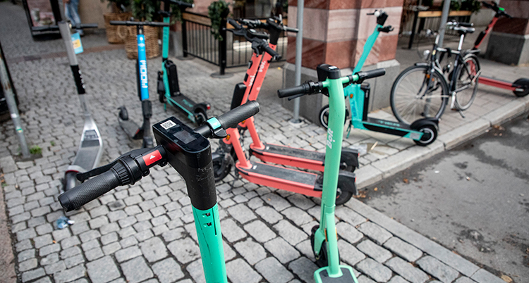 Sparkcyklar på en trottoar.