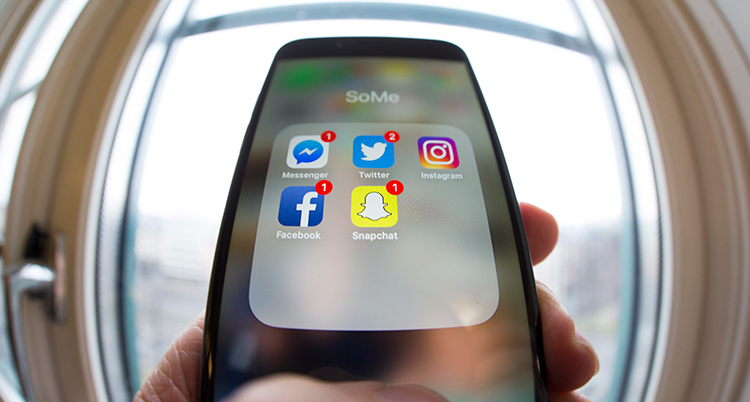 en hand håller en mobil. vi ser sociala medier-appar.