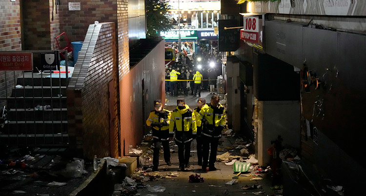 Poliser går på den smala gatan som nu är tömd på människor.