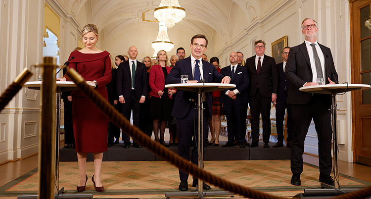 Nya regeringen i en stor sal på en pressträff.