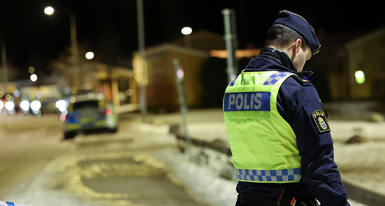 En rygg på en polis med en gul väst.