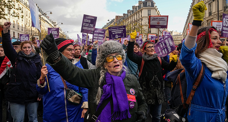Människor håller upp knutna nävar. De går i en demonstration.