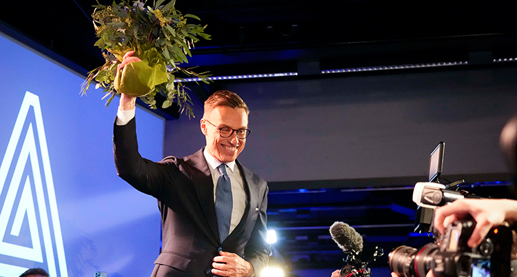 Stubb med en bukett blommor som han håller upp.