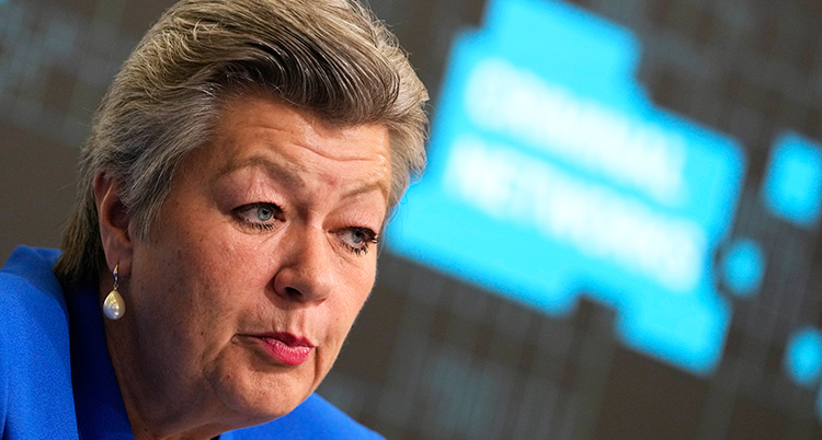Närbild. Hon ser allvarlig ut, i bakgrunden finns en skärm.