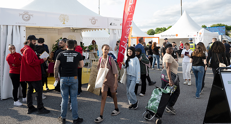 Flera personer går omkring bland olika tält.