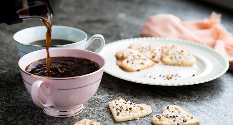 Två koppar med kaffe och ett fat med småkakor.