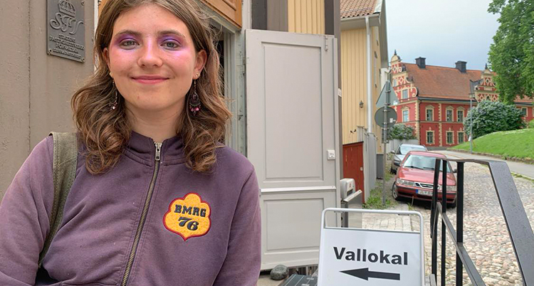 Hon står utanför en vallokal.