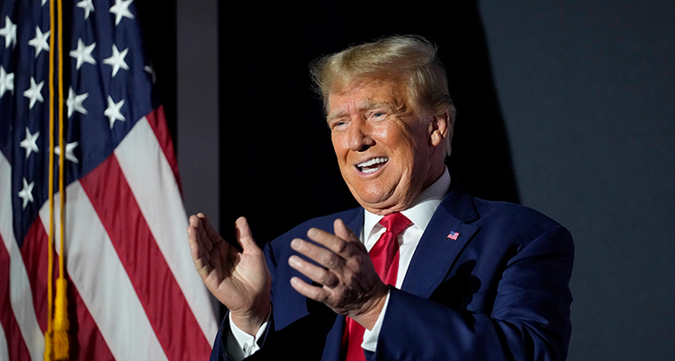 Trump ler och klappar händerna.