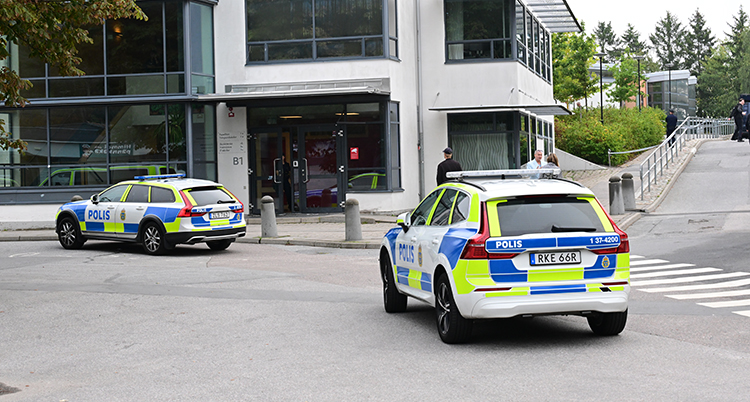 Polisernas har parkerat sina bilar utanför skolan.