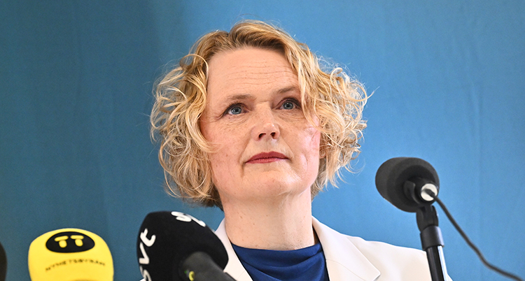 Hon har kort lockigt ljust hår.