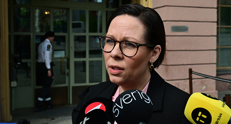 Hon har flera mikrofoner framför sitt ansikte.