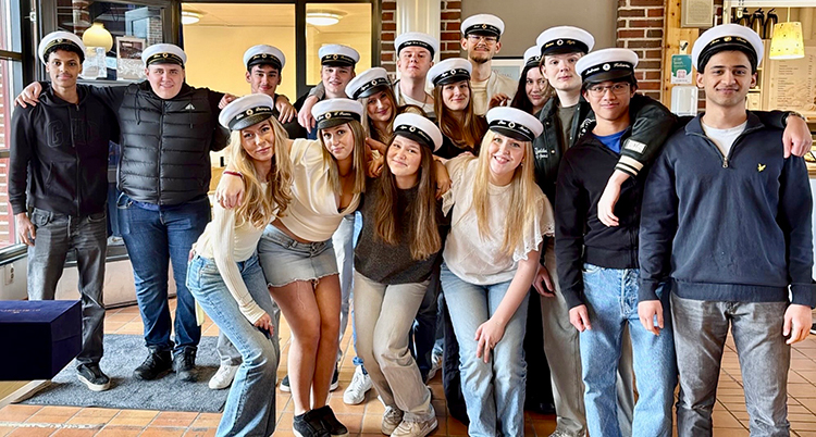 Många unga personer med studentmössor står tillsammans.
