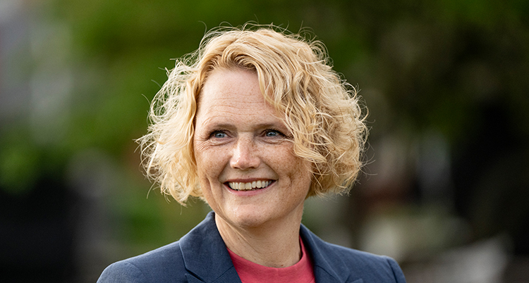 Hon ler. Hon har kort ljust lockigt hår.