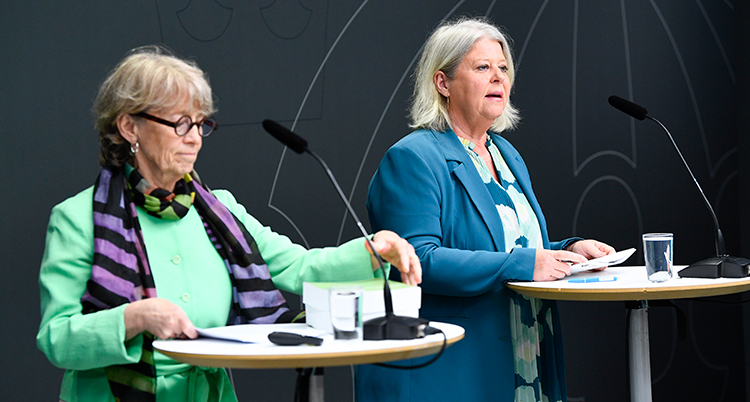 Två kvinnor pratar på en träff med journalister.