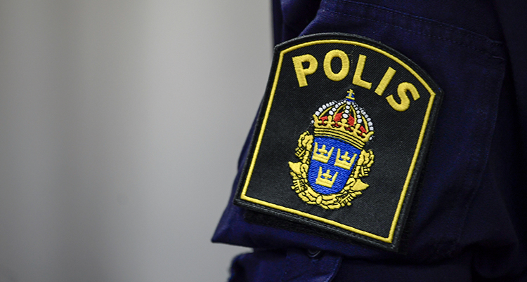 Polisens logga på en persons arm.
