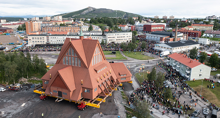 Kyrkan syns stående på en vagn som rullar genom staden.