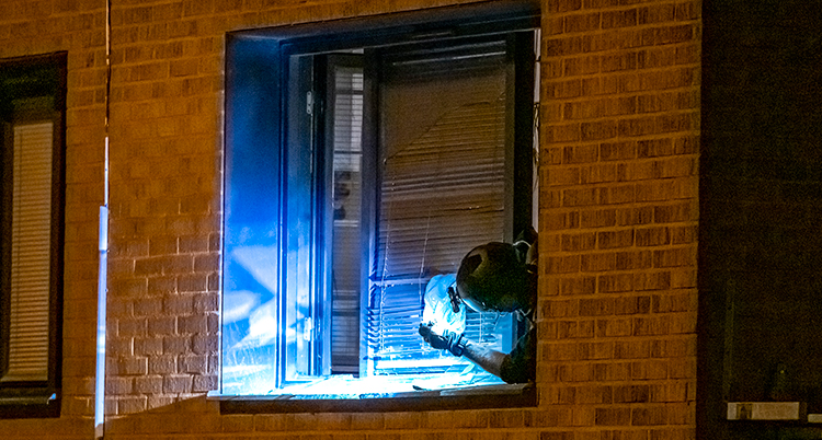 En polis undersöker fönstret där explosionen var.