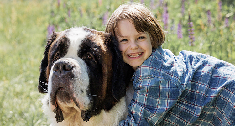 En hund och en flicka som är glad.