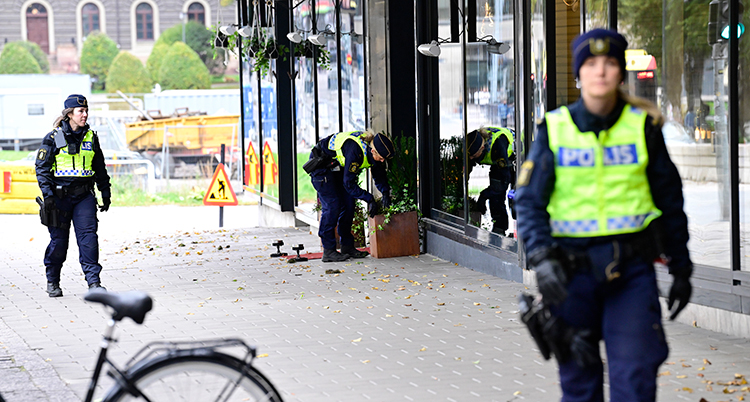 Tre poliser på en gata.