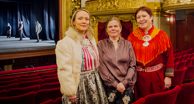 Tre kvinnor står bredvid varandra i en teatersalong. De tittar in i kameran.